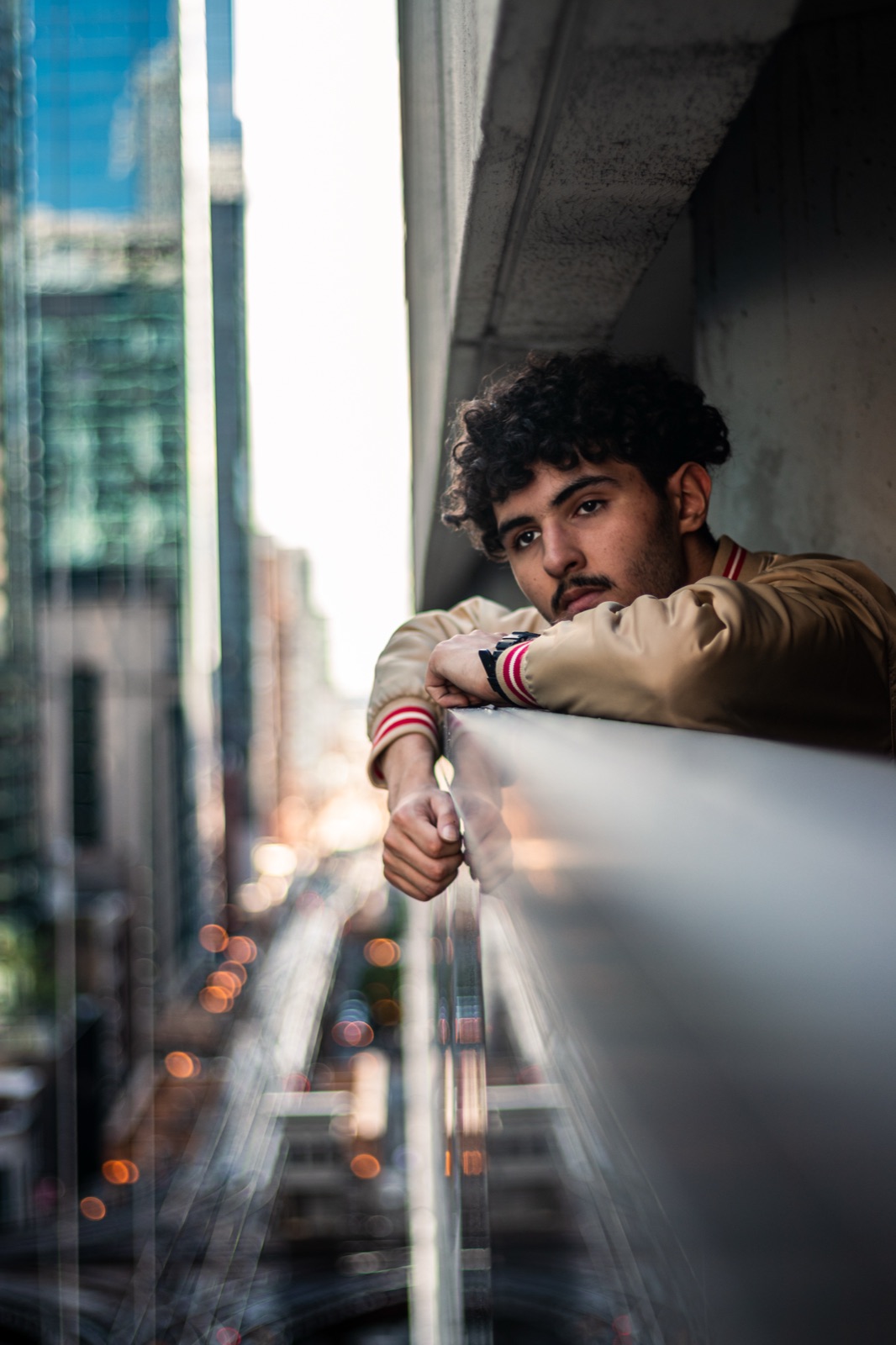 Portrait leaning on a railing above a downtown street