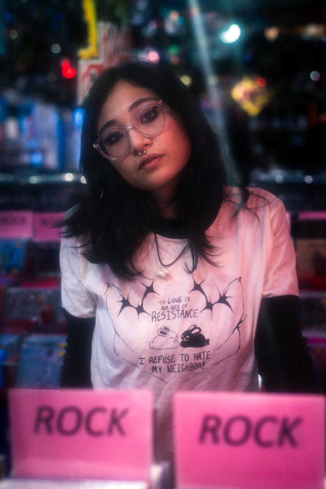 Portrait behind the window of a record shop, neon reflections